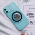 Primer plano de un soporte de anillo magnético Magsafe transparente en un teléfono azul claro. - Hebilla de Anillo Magnética / Negro