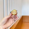 Detail shot of a cute yellow doodle smiley face retractable badge reel for work ID - Graffiti Smiley Face