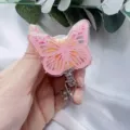 Detailed view of a pink butterfly resin retractable badge reel with gold leaf decoration - Pink Butterfly Yellow Flower