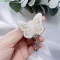 Detailed close-up of a butterfly resin badge reel with elegant gold foil accents - White Butterfly White Flower