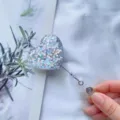 Nahaufnahme der herzförmigen Glitzer-Ausweismarke mit einziehbarer Schnur und Clip. - Silberne Pailletten (Nr. 1)