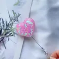 Nahaufnahme einer rosa herzförmigen, ausziehbaren Ausweishülle mit glitzernden Pailletten - Rosa Herz-Pailletten (Nr. 6)