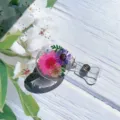 Detailed view of a retractable badge reel featuring real pink and purple flowers in clear resin. - Style 5 Real Flower