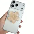 Nahaufnahme einer schimmernden 3D-Kirschblüten-Handyhalterung aus Harz an einem Handy - Magnetischer Ständer / Hellorange