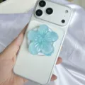Nahaufnahme eines hellblauen 3D-Glitzer-Blumen-Handyhalters aus Harz auf weißem Handy - Magnetischer Ständer / Blau