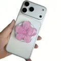 Nahaufnahme eines rosafarbenen Glitzer-Harz-Kirschblüten-Handyhalters auf einem Smartphone - Magnetischer Ständer / Rosé