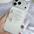 Nahaufnahme der glitzernden weißen Blumen-Handyhalterung aus Harz am Smartphone - Magnetischer Ständer / Weiß