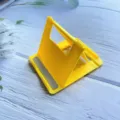 Detail of yellow folding phone stand showing 4-level adjustable angle notches - Bag Packed / Yellow
