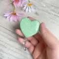 Nahaufnahme eines mintgrünen, herzförmigen, glitzernden, ausziehbaren Ausweises - Mintgrün