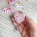 Nahaufnahme eines herzförmigen rosa Glitzer-Ausweishalters für Krankenschwestern. - Lila Rosa