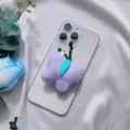 Primo piano del simpatico supporto per telefono a farfalla in peluche viola su smartphone - Supporto a gonfiabile / Farfalla in tessuto viola
