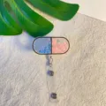 Detailopname van de pilvormige badgehouder met blauwe en roze glitter pailletten - Tweekleurige Capsule Stijl (5)