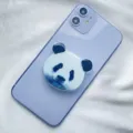 Close-up detail of a cute panda face acrylic phone grip attached to a light purple smartphone - Expanding Stand / Panda Head Type 3