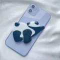 Macro view of a cute acrylic panda phone socket grip attached to a purple smartphone - Expanding Stand / Crawling Panda
