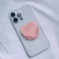 Close-up of a pink shell heart phone grip attached to a smartphone with MagSafe design. - Heart Magnetic Holder / Pink Scallop