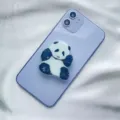 Close-up of a cute acrylic panda phone socket grip on a light purple smartphone - Expanding Stand / Sitting Raised Hand Panda