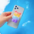 Detailaufnahme eines süßen regenbogenfarbenen Bären-Handyhalters auf einem Smartphone - Erweiterbarer Ständer / Regenbogen Bär Stil 1