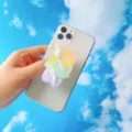 Nahaufnahme eines süßen regenbogenfarbenen Bären-Handyhalters auf einem weißen Smartphone. - Erweiterbarer Ständer / Regenbogen Bär Stil 3