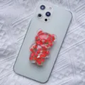 Cute 3D resin bear phone grip accessory with strawberry pattern on light green phone - Expanding Stand / Strawberry Bear