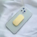 Dettaglio di un supporto per telefono scorrevole giallo macaron su uno smartphone. - Supporto Scorrevole / Giallo latte