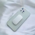 Primo piano di un supporto per telefono bianco a forma di pillola su uno smartphone verde - Supporto Scorrevole / Bianco