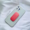 Vista dettagliata di un supporto per telefono a molla rosa su uno smartphone verde. - Supporto Scorrevole / Rosso anguria