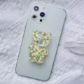 Close-up of a cute transparent bear phone grip with pineapple pattern on a light green phone. - Expanding Stand / Pineapple Bear