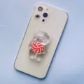 Close-up of a transparent bear-shaped phone grip with a red swirl lollipop detail - Expanding Stand / Red Lollipop Bear