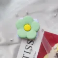 Close-up van een groene bloemvormige opvouwbare telefoonhouder met een spiegel - Uitbreidbare Standaard / Groene Bloem Met Spiegel