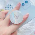 Detailopname van een holografische telefoonhouder met vlinderontwerp op een blauwe gsm - Zwarte Vlinder (1.5) / 1.5
