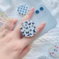 Close-up van een uitschuifbare telefoonhouder met vlinderpatroon op een smartphone. - Kleurrijke Textuur (1.6) / 1.6