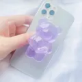 Close-up van een schattige doorschijnende paarse beervormige telefoonhouder op een smartphone - Uitbreidbare Standaard / Paars Translucent Beer