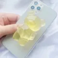 Close-up van gele doorschijnende gummibeer telefoonhouder op een smartphone - Uitbreidbare Standaard / Geel Translucent Beer