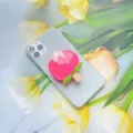 Gedetailleerde macro-opname van een schattige roze hars telefoonhouder in de vorm van een ijsje - Uitbreidbare Standaard / Roze Perzik