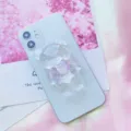 Primo piano di un supporto per telefono a forma di orso iridescente con fiocco rosa - Supporto a gonfiabile / Orsetto con Fiocco Rosa
