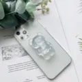 Primo piano di un supporto per telefono a forma di orso glitterato su uno smartphone verde - Supporto Orso / Glitter Colorato