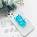Primo piano di un simpatico supporto per telefono a forma di orsetto blu traslucido - Supporto Orso / Celeste