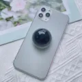 Supporto per telefono a sfera di cristallo nera montato su uno smartphone grigio - Supporto a gonfiabile / Sfera di Cristallo Nera