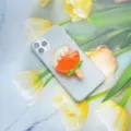 Detailweergave van een oranje ijsje-vormige hars telefoonhouder op een smartphone - Uitbreidbare Standaard / Oranje