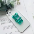 Dettaglio di un simpatico supporto per telefono a orsetto verde su uno smartphone - Supporto Orso / Verde Scuro