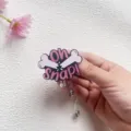 Close-up detail of funny acrylic Oh Snap bone badge reel with pink glitter finish - Oh Snap Style (Broken Bone)