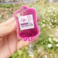 Retractable pink liquid glitter badge reel shaped like a blood bag with heart label - Blood Bag 5 (Pink Cells)