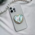 Macro view of a colorful iridescent shell heart-shaped magnetic phone grip on a white phone. - Heart-Shaped Stand / Green Scallop Shell Gold Base Magnetic - Heart Shaped