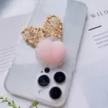 Close-up detail of a cute pink heart-shaped squeeze toy phone socket grip on clear phone case - Pink Heart Style