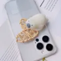 Close-up of a cute 3D polar bear squeeze toy phone grip attached to a clear case - Polar Bear Style