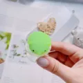 Hand holding a cute green hedgehog squishy phone socket stand for stress relief - Green Hedgehog Style