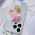 Close-up of pink starfish squishy phone grip on transparent case with straw heart prop. - Pink Starfish Style