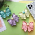 Détail de quatre supports de téléphone en résine époxy transparente en forme de fleur colorée - Nœud / Rose