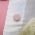 Gedetailleerd overzicht van de ronde, macaronroze inklapbare telefoonhouder - Uitbreidbare Standaard / Roze