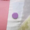 Detailopname van een glanzende paarse macaronkleurige ronde telefoonhouder. - Uitbreidbare Standaard / Paars